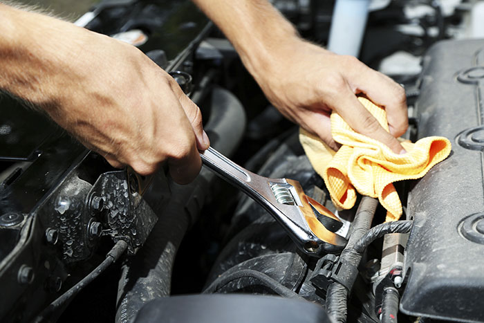 Hand with wrench. Auto mechanic in car repair